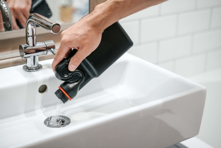pouring drain cleaner into sink