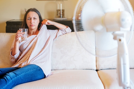woman cooling off in front of a fan