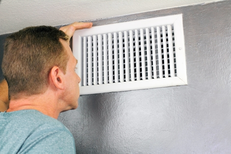 man inspecting air duct