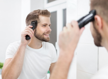 man shaving hair over bathroom sink